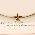 Close-up of a 20mm amber star-shaped acrylic rhinestone with a multifaceted cut finish - 20mm Star / Orange