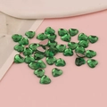 Dettaglio macro di strass acrilici a forma di cuore verde smeraldo con base piatta argento - Cuore Piatto 8mm / Verde