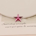 Macro detail of star-shaped pink acrylic flatback rhinestones with faceted crystal cuts - 20mm Star / Rose Red