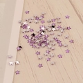 Vue détaillée de cristaux en forme d'étoile de 3mm pour nail art sur fond de bois - Violet Argent (18#)