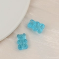 Close-up of translucent light blue resin gummy bear charms for DIY hair accessories - Blue