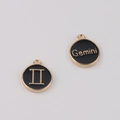 Détail d'un pendentif zodiaque Gémeaux rond avec émail noir et gravure de lettres dorées - Gémeaux / Noir