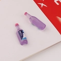 Macro view of purple miniature resin beer bottles for DIY craft and phone case decoration - Purple