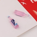 Close-up of pink resin miniature beer bottles with Snow logo for DIY crafts and decor - Pink