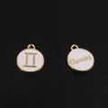 Détail macro du pendentif zodiaque Gémeaux en alliage doré avec émail blanc et symboles - Gémeaux / Blanc
