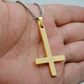 Collier pendentif croix inversée dorée pour homme en acier brossé tenu dans la main - Chaîne Givrée / Or