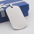 Primer plano del colgante de placa de identificación de acero plateado sobre caja de regalo azul - Colgante Redondeado Color Acero Solamente (Sin Cadena)