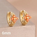 Macro shot of 6mm gold huggie earrings featuring vibrant orange clover-shaped zirconia - 6mm-Gold Orange-1 Pair