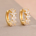 Close-up of gold-plated huggie earrings with sparkling clear zircon inlay on beige stand - Gold White Style (Y26823)