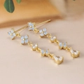 Detail of long gold chain earrings with blue flower petals and sparkling crystal teardrops - Long Tassel Dangle Earrings (Y20311) / Gold