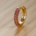 Dettaglio ravvicinato di orecchini huggie dorati con tre file di zirconi rosa pavé - Oro (Strass Rosa)