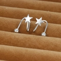 Macro shot of silver star-shaped ear cuff on brown velvet tray with polished metal finish - Silver Star