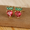 Macro detail of strawberry earrings featuring heart-shaped red zircon and green leaves - Strawberry