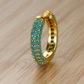 Dettaglio macro di orecchini a cerchio dorati con pavé di turchese su legno chiaro - Oro (Strass Celeste)
