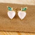 Macro shot of 18K gold-plated peach stud earrings with heart pink zircon and green leaf - Peach
