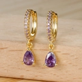 Vue macro de boucles d'oreilles créoles dorées avec zircon goutte violet sur socle bois - Boucles d'Oreilles Pendantes Zircon Violet Or (Y20291) / Or
