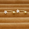 Detail of star-shaped gold piercing with clear crystal and curved barbell back - Gold Style (Y20295)