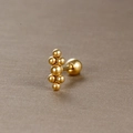 Détail macro de clous d'oreilles boules dorés géométriques avec fermeture à vis sur fond texturé - Style Cluster Symétrique à Sept Boules (Y20419-5) / Or