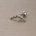Détail macro d'un piercing incurvé en acier inoxydable avec sept billes argentées - Style Arc Dégradé à Sept Boules (Y20419-7) / Argent