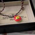 Detailed macro view of a colorful braided rope bracelet with a red enamel smiley face charm - Smiley Style / Multicolor Woven