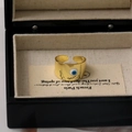 Détail d'une bague œil protecteur plaquée or 18 carats avec émail bleu sur présentoir - Blanc