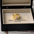 Vista dettagliata dell'anello Evil Eye placcato oro 18 carati in una confezione regalo nera - Rosa