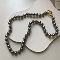 Vue détaillée du collier de perles gris argenté doté d'un fermoir métallique doré noué - 8mm Perles Multicolores Gris Foncé (Style Noué)