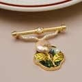 Detalle macro de broche vintage francés con perla barroca, esmalte verde y cristales - Estilo Perla de Agua Dulce Oro 16K