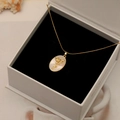 Collier ovale doré avec nacre naturelle et motif floral dans son écrin cadeau - Violette d'Août
