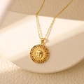 Gros plan du collier pendentif soleil vintage avec zircons colorés sur pierre blanche - Soleil en Zircone Colorée