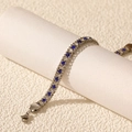 Detailed macro view of silver tennis bracelet with alternating blue and white zircon stones - Silver Blue & White Zirconia