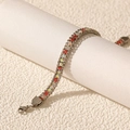 Détail d'un bracelet argenté brillant orné de cristaux rouges et irisés AB - Argent Zirconia Multicolore