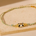 Gros plan d'un collier en cordon tissé avec un pendentif en émail doré style tarot - Collier Cœur Noir