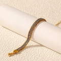 Détail d'un bracelet plaqué or 18 carats avec des oxydes de zirconium bleus sur un support - Or Zirconium Bleu