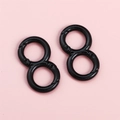 Zwei glänzende schwarze 8er-Karabinerhaken auf einem sauberen rosa Hintergrund - Schwarz