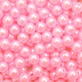Macro shot of pink acrylic imitation pearls with pre-drilled holes for DIY jewelry making - Pink