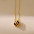 Gold zodiac necklace featuring Cancer sign cutout pendant with dark center stone - Cancer
