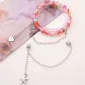 Perlenarmband in Rosa und Orange mit Seestern- und Herzanhängern auf einer Deko-Karte - Seestern