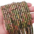 Perles cylindriques en unakite avec motifs verts et roses présentées dans la main - Tube 4x13mm Trou 0.8mm 38cm Par Fil Environ 30 Perles / Unakite