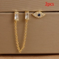 Makro-Detail von vergoldeten Evil Eye Steckern und Zirkonia-Kettenohrringen auf Display - Zweifach-Piercing Kette Böser Blick Zweiteiliges Set (Y25021-5) / Gold