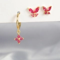 Dettaglio di orecchini dorati con farfalle in zircone rosso e cerchi con ciondoli - Stile Farfalla Stellare (Y25027-7)