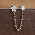 Macro-opname van een zilveren dubbele piercing ketting oorbel op een bruine lederen doos - Zilveren Stijl (Y20421-3)