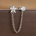 Detail van dubbele piercing oorbellen met zirkonia bloem en fijne zilverkleurige ketting - Zilveren Stijl (Y20421-4)