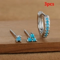 Detalle de set de 3 pendientes plateados con piedras turquesas sobre madera - Plata-Azul