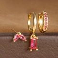 Detalle macro de pendientes de aro bañados en oro y tachuelas con circón rosa en soporte - Juego Circonia Roja Oro