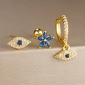 Detalle de juego de tres pendientes dorados de ojo turco con cristales azules en soporte - Juego de 3 Piezas Ojo Turco Colgante Flor (Y26036-7)