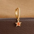 Detalle macro de pendiente de estrella dorada con piedra naranja y circonitas - Estilo de Estrella Piedra Central Naranja (Y76007)