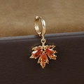 Makroaufnahme der S925 Silber Ahornohrringe mit orangen Zirkonia auf Leder - Ahornblatt Hoop Ohrring / Gold-Orange