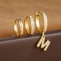 Detail van gouden oorbellen met een gladde ring, CZ-pave hoop en een hanger met letter M - Letter M Stijl (Y26056-M)