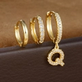 Macro-opname van gouden oorringen met letter Q en zirkoon op een lederen doosje - Letter Q Stijl (Y26056-Q)